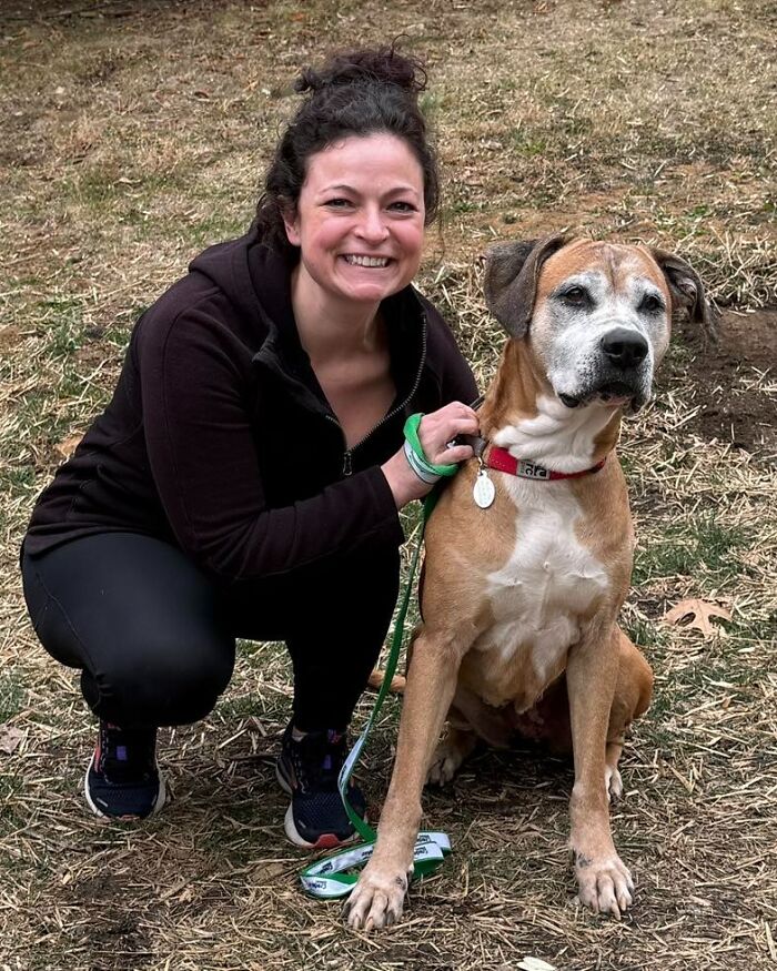 A woman smiles alongside a 12-year-old rescued pup ready for adoption. A woman smiles alongside a 12-year-old rescued pup ready for adoption.