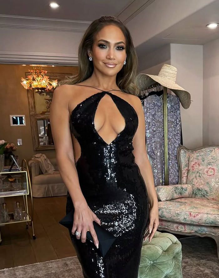 Jennifer Lopez in glamorous sequined dress stands confidently, showcasing a stylish and bold fashion choice in an elegant room. Jennifer Lopez in glamorous sequined dress stands confidently, showcasing a stylish and bold fashion choice in an elegant room.