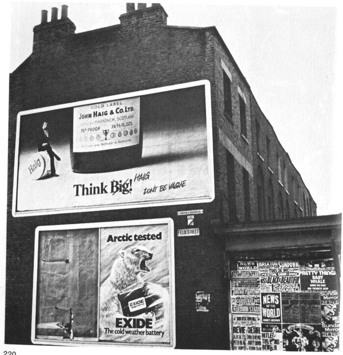 1973 building with vintage billboards featuring Haig whisky and Exide battery ads, set on a street corner.