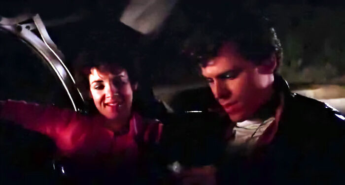 Two people in a car, one in a red shirt, referencing movie jokes that took years to understand.