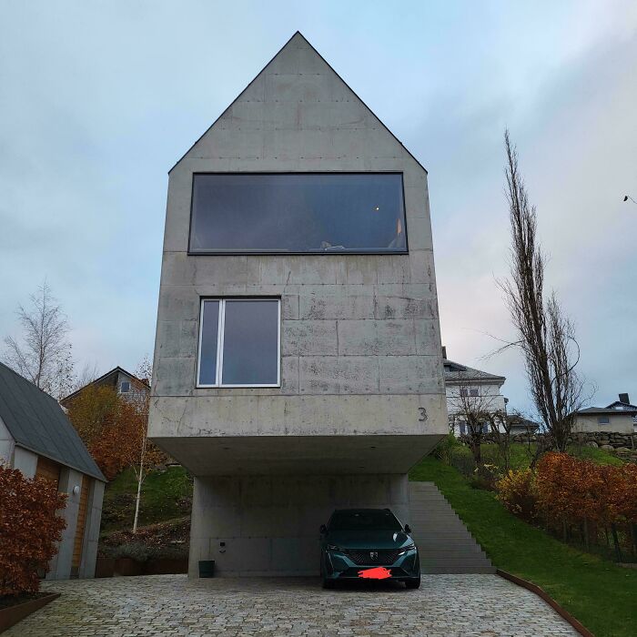 Concrete building with sharp angles and dark windows, exuding an evil aura like a supervillain headquarters exterior.
