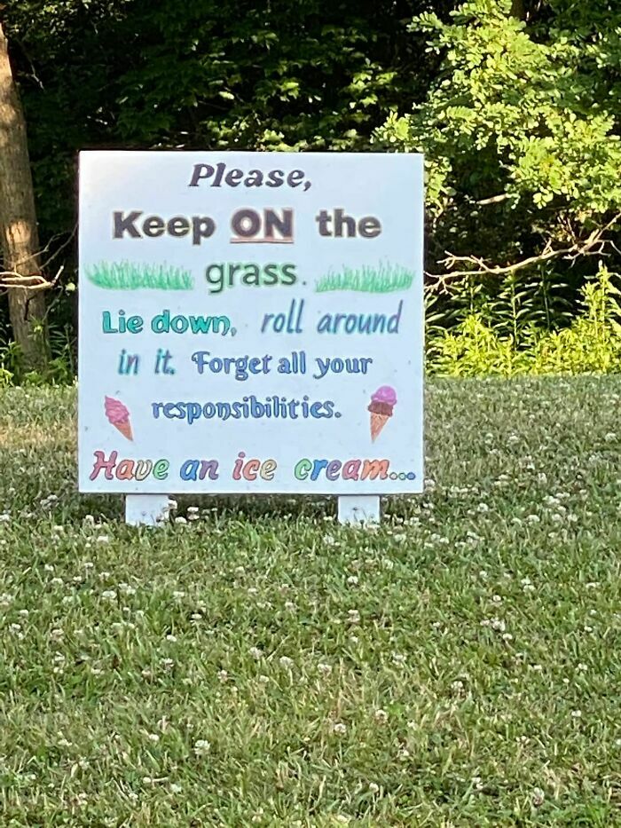 Wholesome sign in a grassy park encouraging people to relax and enjoy ice cream.