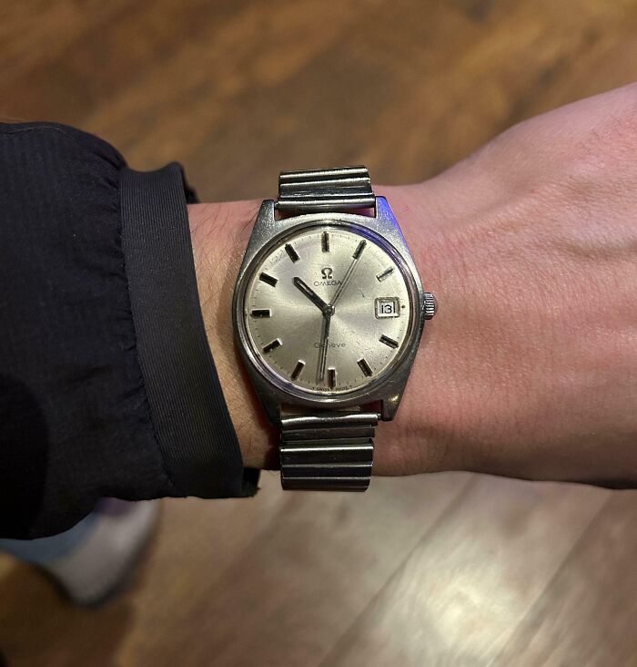 Vintage Omega wristwatch with metal band worn on wrist, showcasing a cool inheritance item in a casual setting.