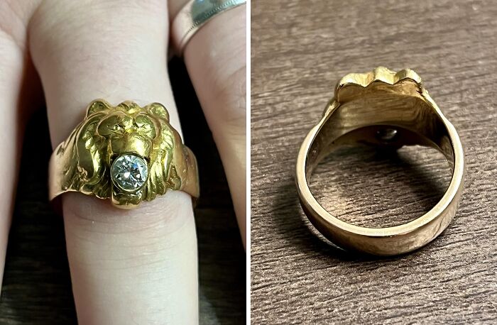 Gold lion head ring with a diamond centerpiece shown on finger and resting on wooden surface, a unique inheritance piece.