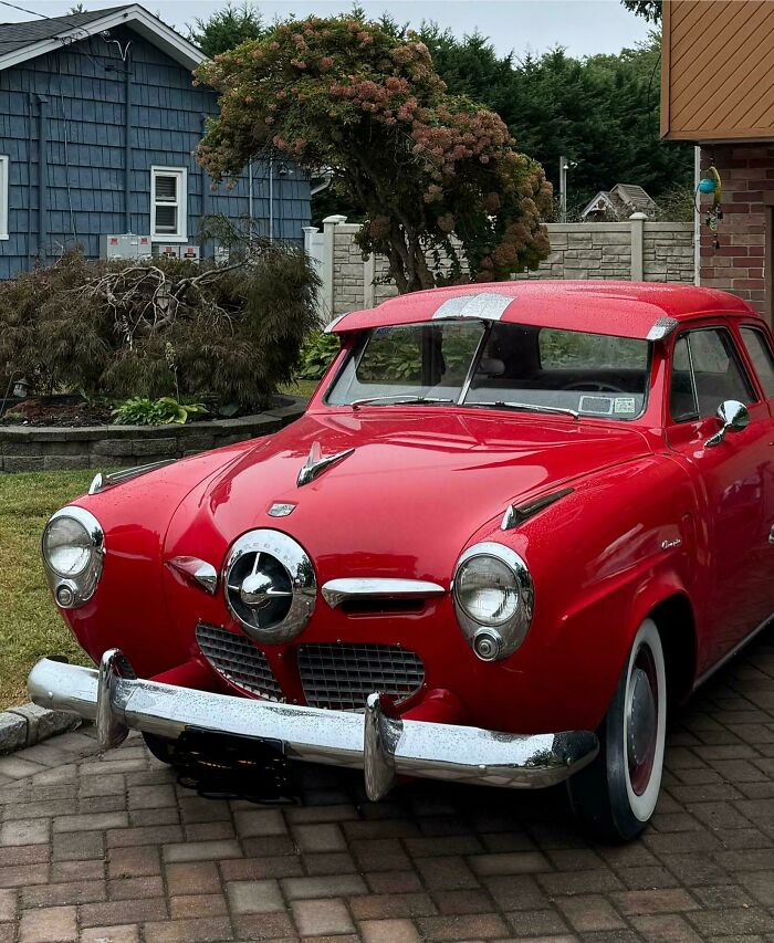 Vintage red Studebaker car parked in a driveway, an example of a cool inheritance from classic vehicles shared by people.