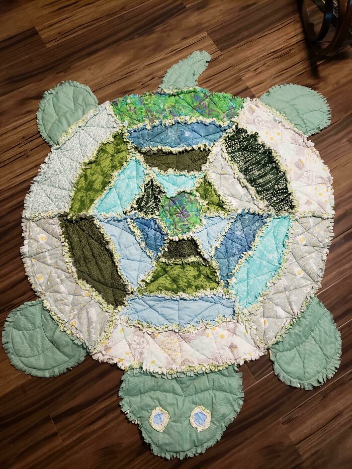 Patchwork turtle quilt on wooden floor, showcasing creativity inspired by amazing mothers-in-law.