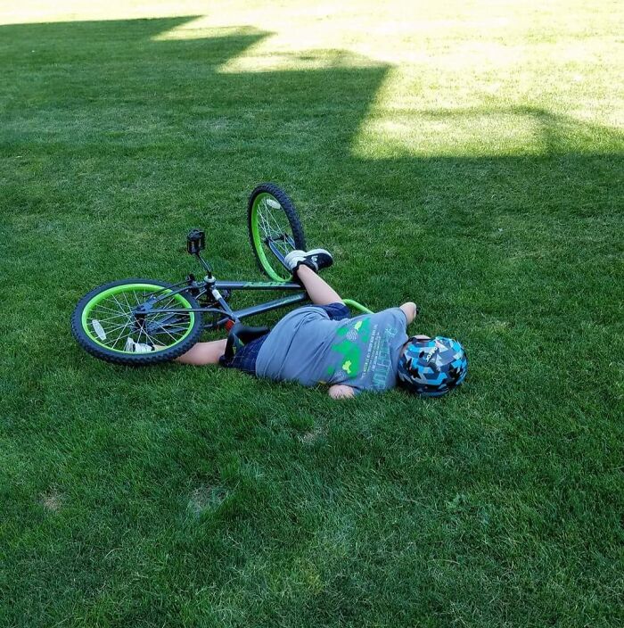 Child in a funny mishap with a bicycle on the grass, capturing the essence of hilarious in-laws scenarios.
