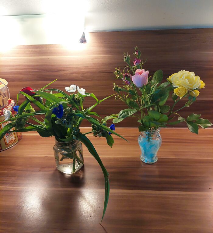 Two vases of colorful flowers on a wooden countertop, symbolizing thoughtful gestures from amazing mothers-in-law.