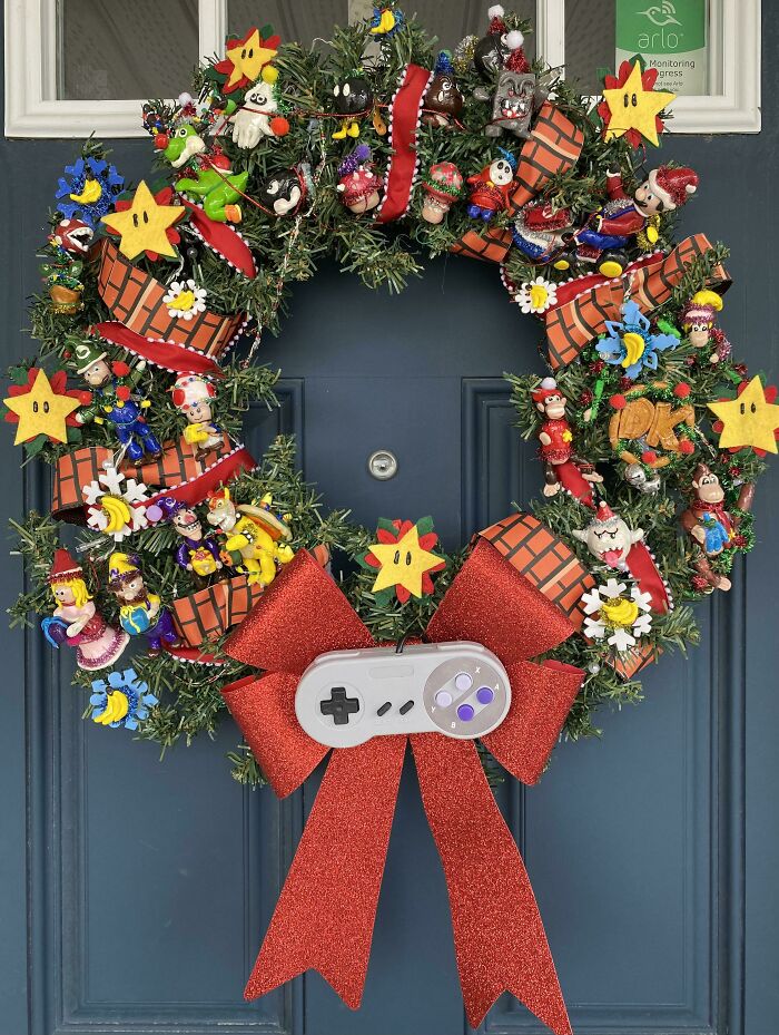 Festive DIY Christmas wreath featuring gaming theme, adorned with colorful ornaments, red bow, and a game controller.