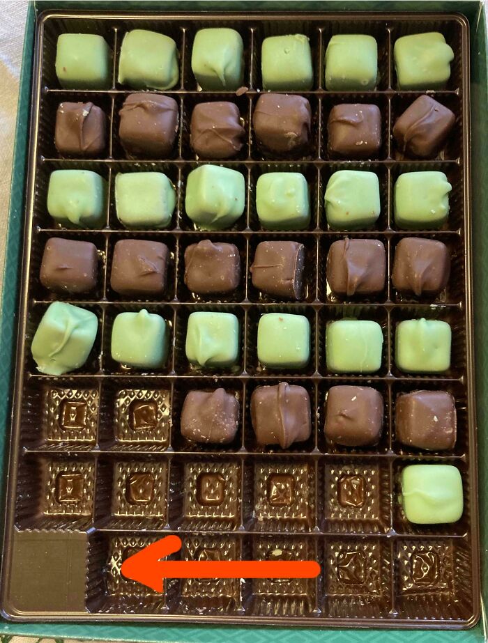 Misleading packaging example: chocolate box with empty slots and an arrow pointing at them.