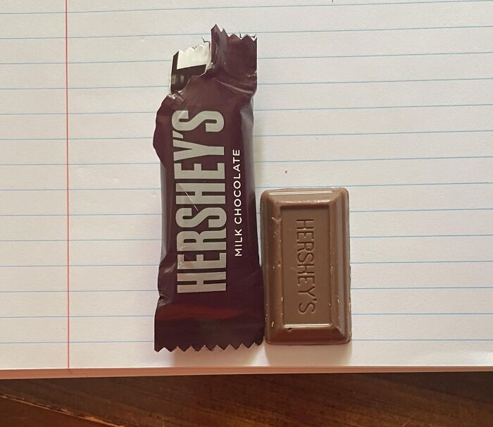 Hershey's chocolate next to its misleading packaging design on a lined notebook.