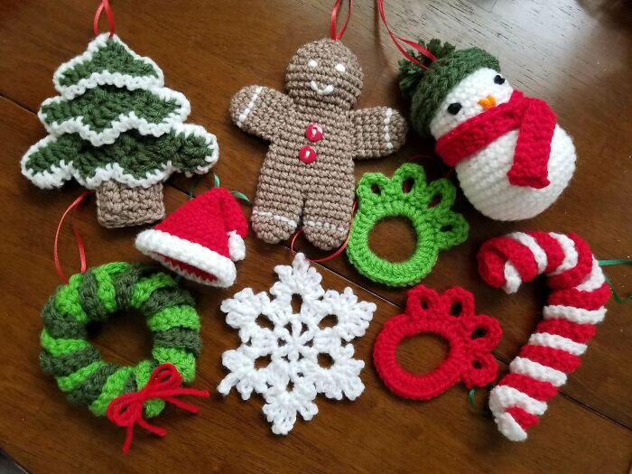 Handmade crochet Christmas decorations, featuring a snowman, gingerbread man, tree, and wreath.