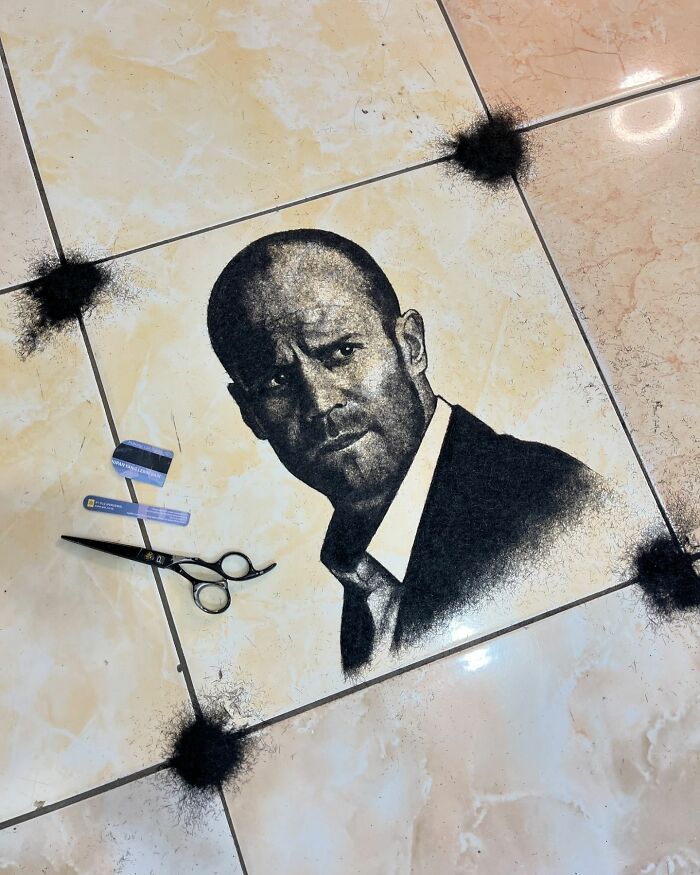 Creative barber portrait using cut hair, depicting a man in a suit on tiled floor with scattered hair pieces and scissors.