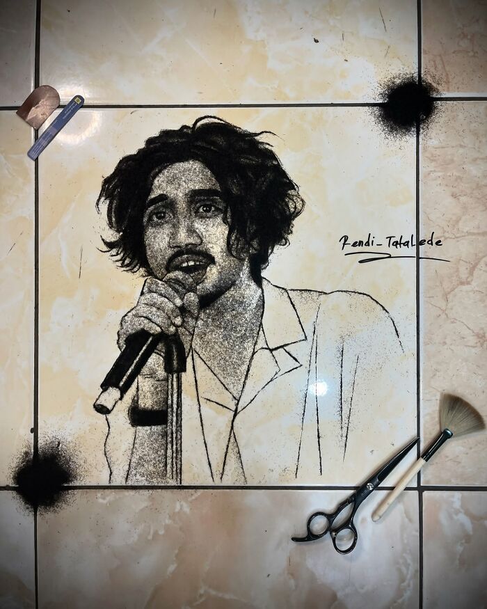 Portrait of a person singing, creatively made from cut hair, displayed on a tiled floor with scissors and tools nearby.