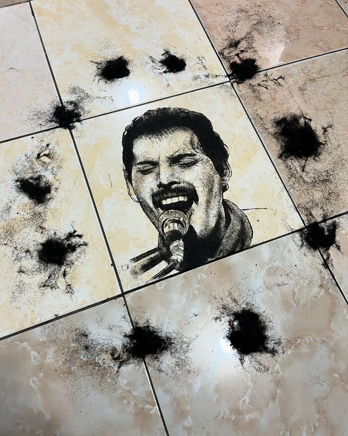 Creative barber's unique portrait made using cut hair on a tiled floor.