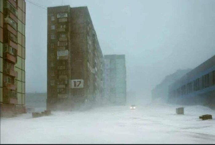 Urban hell: bleak scene of Soviet-style apartment blocks shrouded in fog, capturing an eerie and desolate atmosphere.