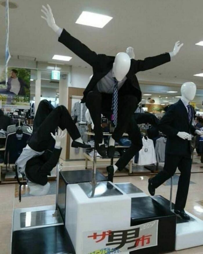 Mannequins in dynamic poses with suits and ties, showcasing "Pics That Go Hard" theme in a clothing store display.
