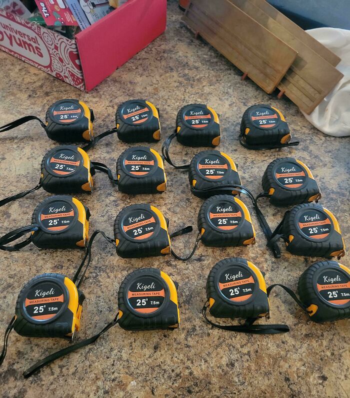 Seventeen identical measuring tapes on a table, a funny trolling Christmas gift idea.