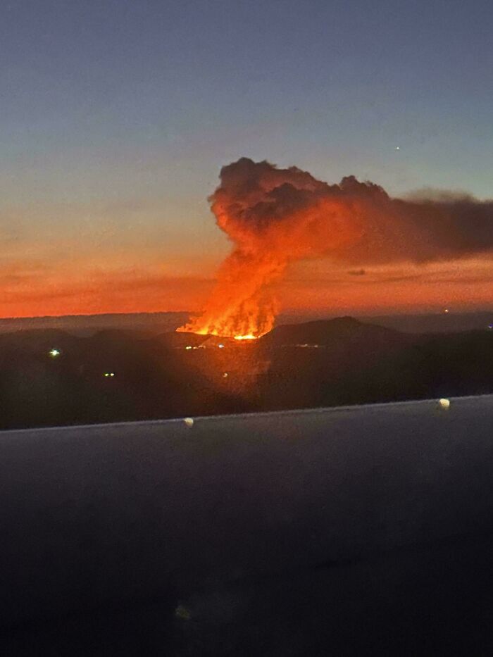 Flames and smoke rise dramatically from a landscape at sunset, showcasing terrifying nature.