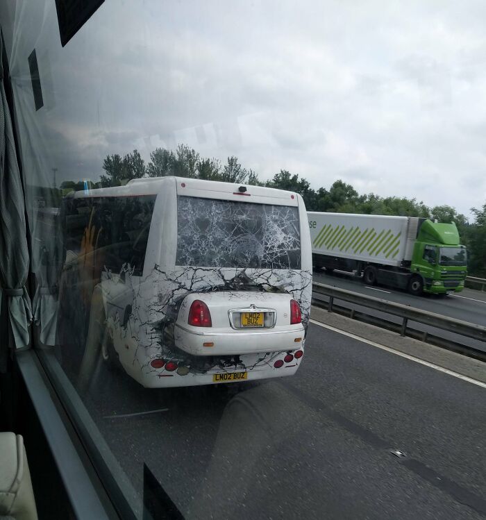 Bus with a humorous design on the highway, simulating a c*****d window with a car's rear.