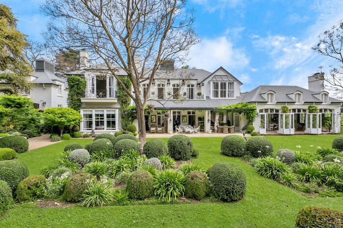 Luxury house with manicured garden, showcasing wealth but challenging the idea that money buys taste.