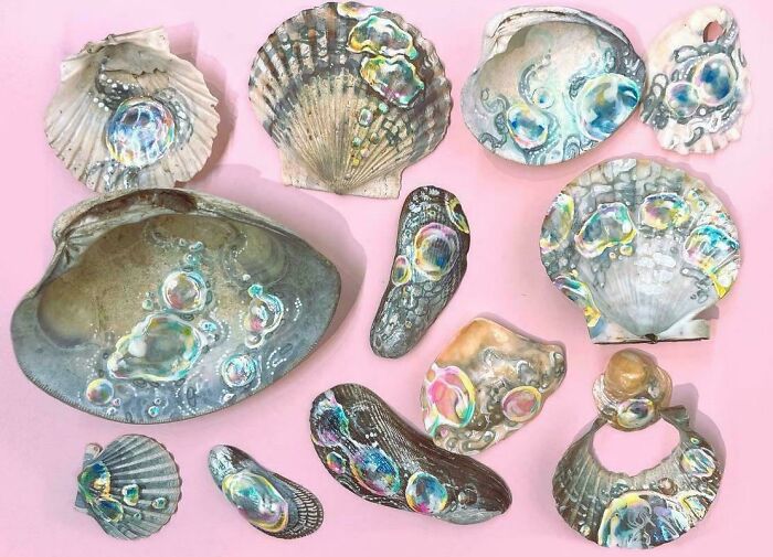 Unique shell collection with iridescent designs on a pink background.
