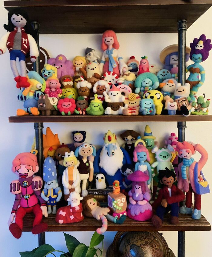 Plush toys arranged on wooden shelves, showcasing an unexpected unique collection of colorful characters.