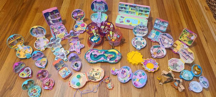 Unique collections of vintage compact toys arranged on a wooden floor.