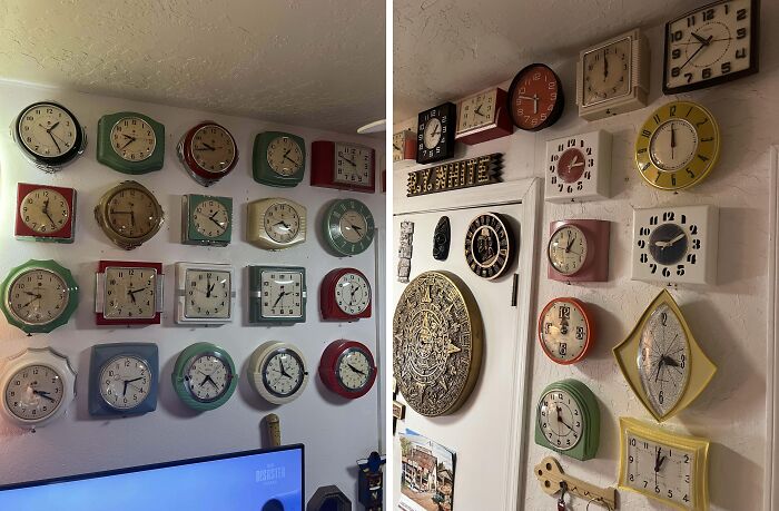 A unique collection of vintage wall clocks in various colors and shapes displayed on white walls.
