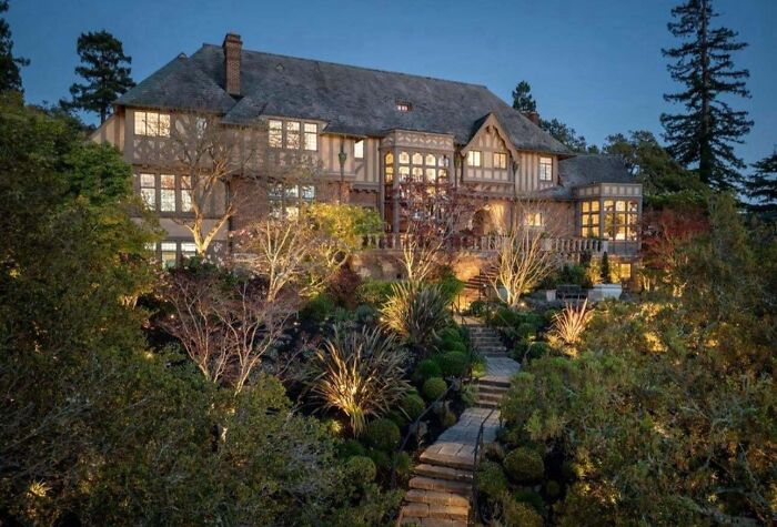 Luxurious house at dusk with intricate landscaping, illustrating that money can’t buy taste.