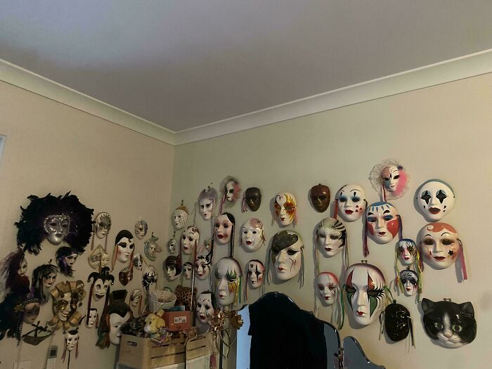 Wall adorned with an unexpected unique collection of decorative masks in various designs and colors.