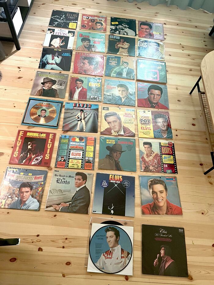 Unique collections of Elvis Presley vinyl records displayed on a wooden floor.