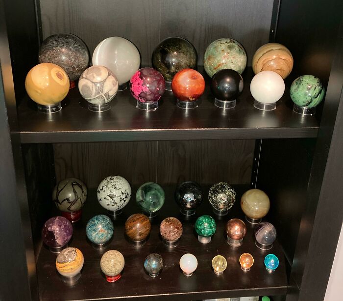 Unique collections of colorful stone spheres displayed on shelves.