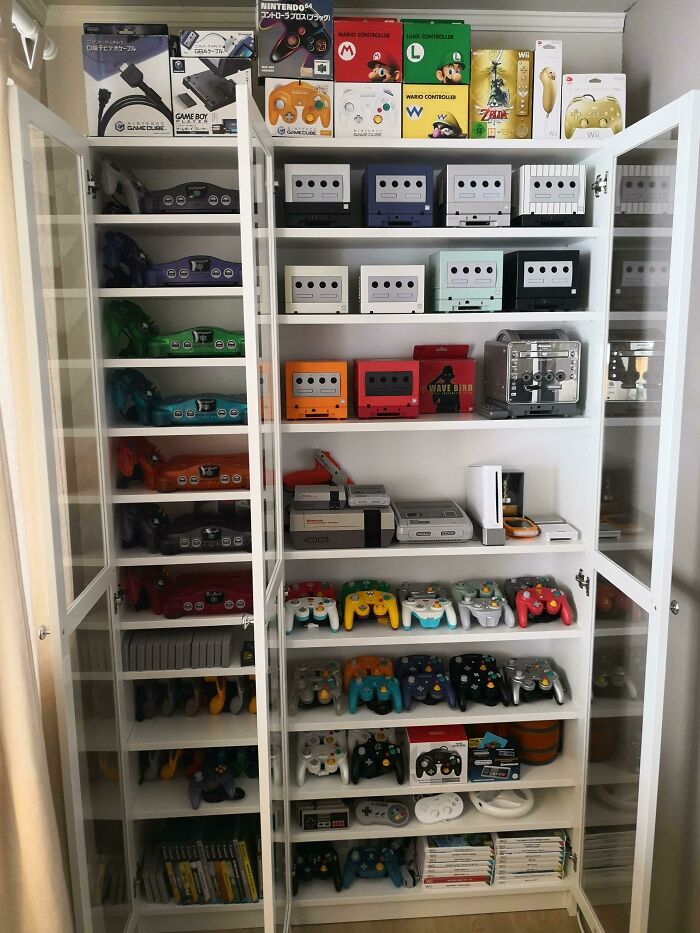 Cabinet filled with unexpected unique collections of vintage Nintendo gaming consoles and controllers.