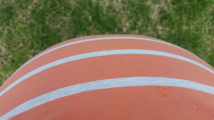 Close-up of a pregnant belly wearing a striped orange shirt, illustrating funny pregnancy situations.