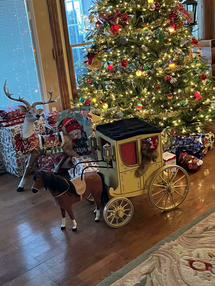 Toy horse and carriage amidst Christmas presents under a decorated tree, symbolizing disappointing gifts.