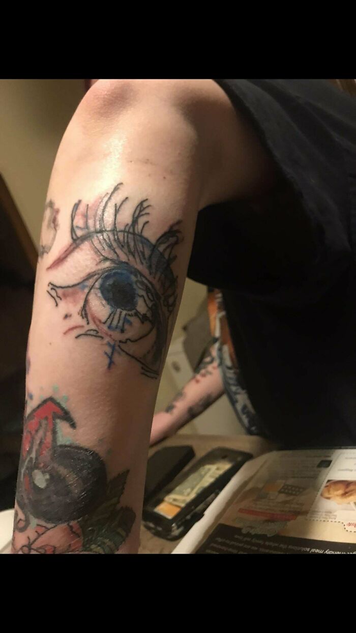 Close-up of a tattoo mishap with a large, distorted eye on an arm, exemplifying funny worst tattoo fails.