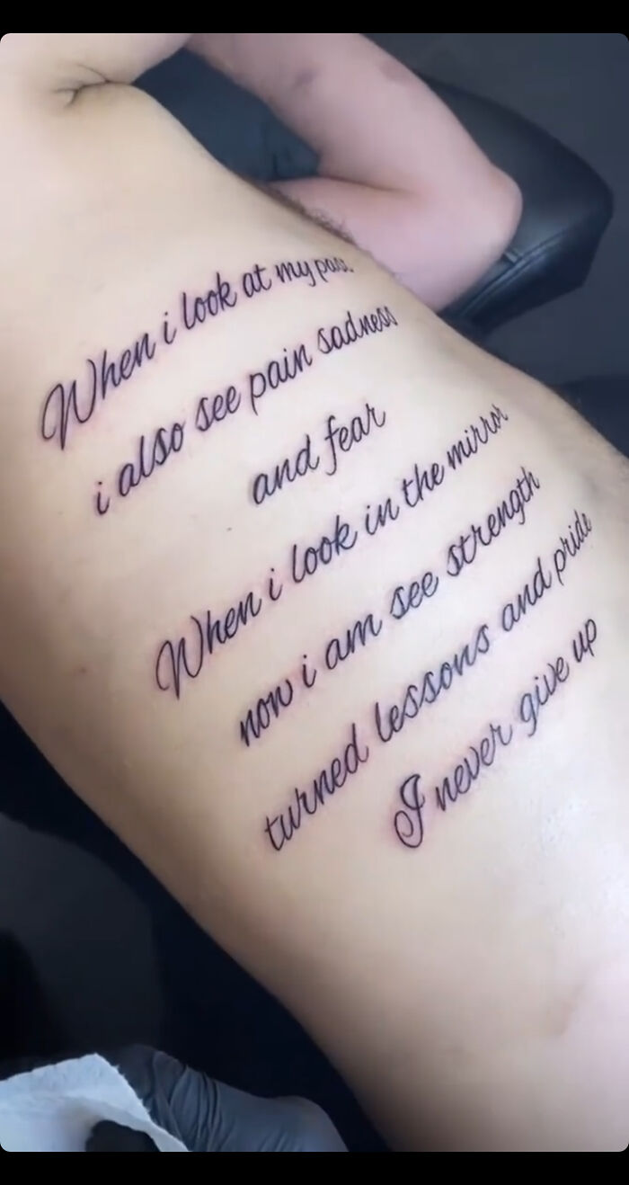 Tattoo fail with misspelled words and awkward phrasing on someone's back.