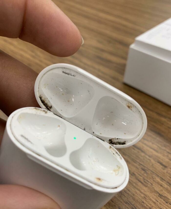 Disappointing gift of dirty earbuds case shown open with visible grime on the edges.