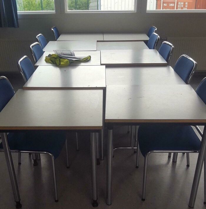 Empty school desks arranged awkwardly illuminating a typical US school experience.