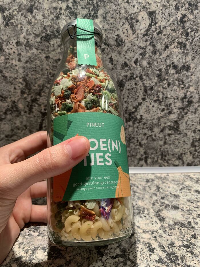 Hand holding a bottle of dried soup mix on a countertop, depicting a disappointing gift.