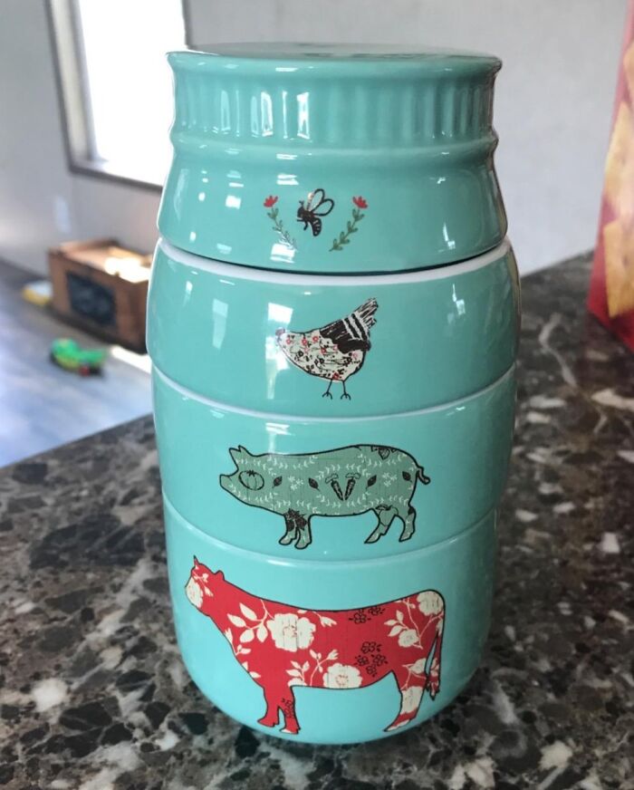 Stackable kitchen storage containers with quirky animal designs on a kitchen counter.