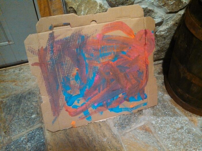 Colorful child painting on cardboard, showcasing a creative and resourceful parenting trick.