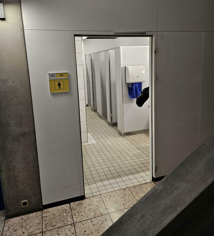 School bathroom with open stall doors, reflecting typical US school experiences.