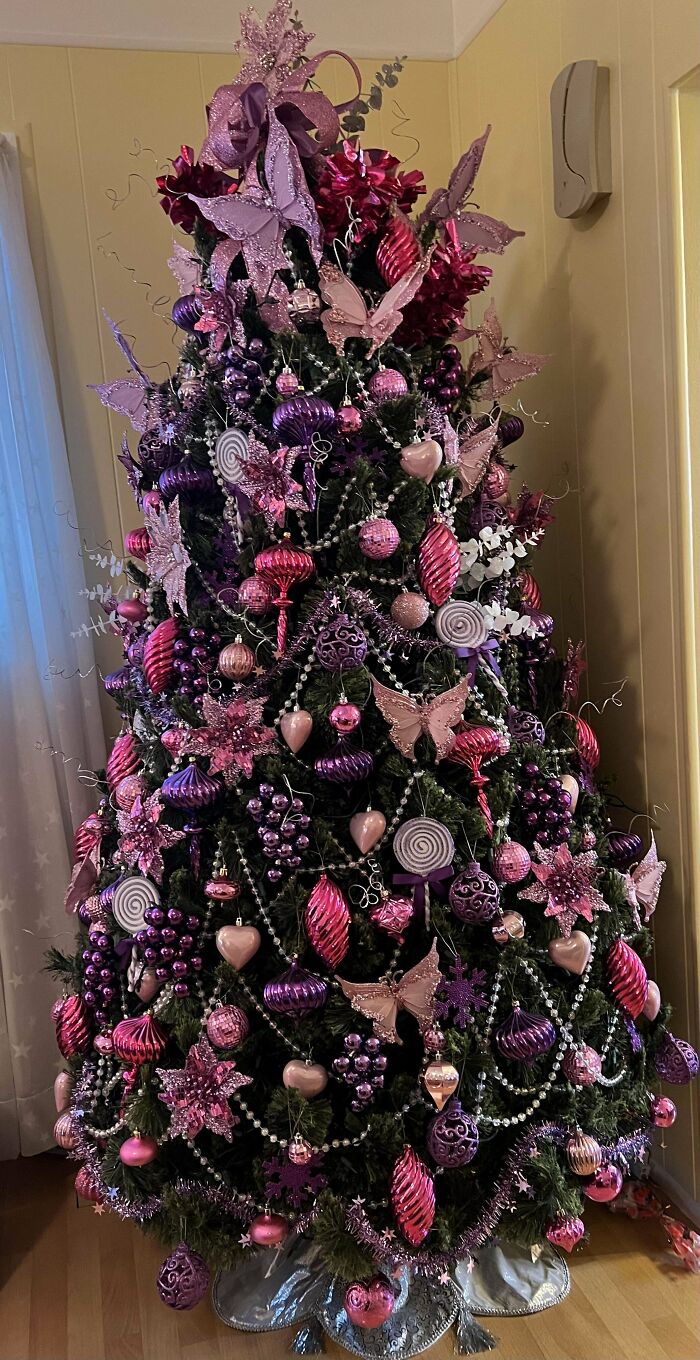 Purple and pink decorated Christmas tree idea with butterflies, stars, and ornaments.