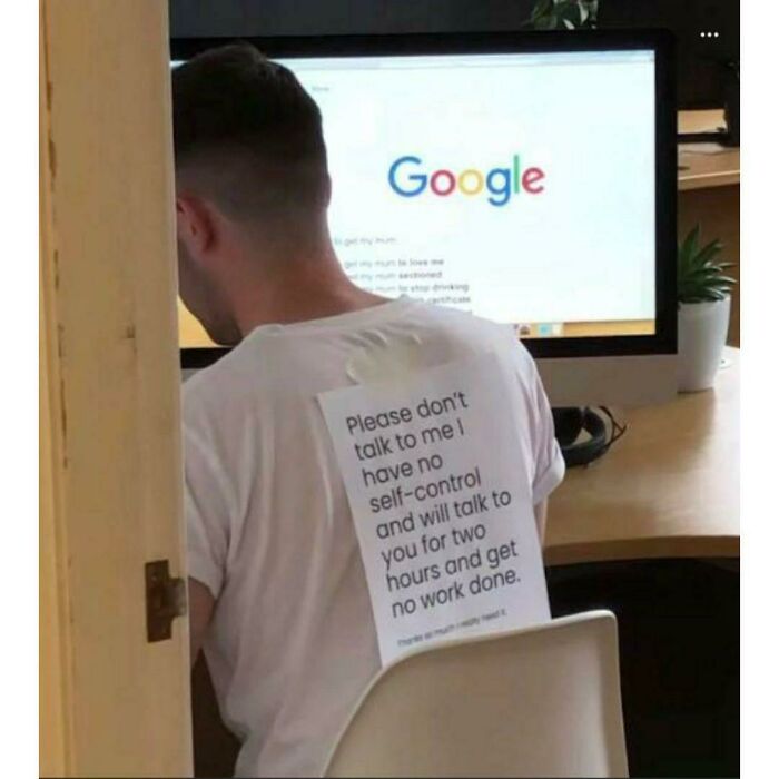 A person with a humorous note on their back, sitting at a desk with Google open on a computer. Mental health meme.