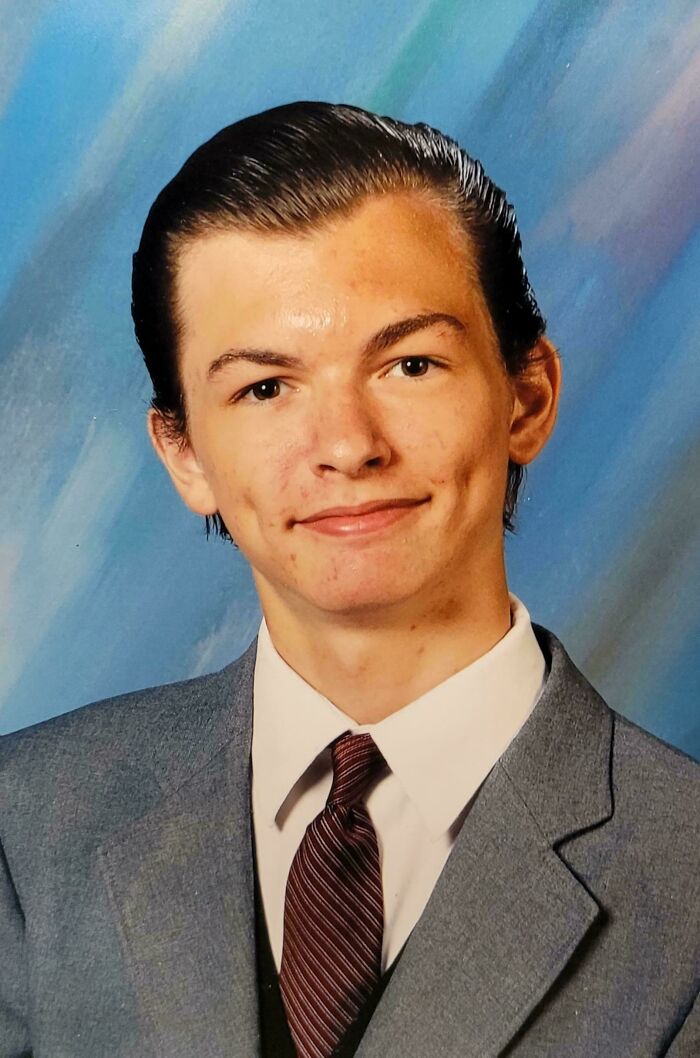 Young man in a suit with slicked-back hair, representing blunder years with a classic awkward school photo.