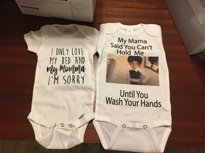 Two humorous baby onesies with funny pregnancy situations messages about love and hygiene on display.
