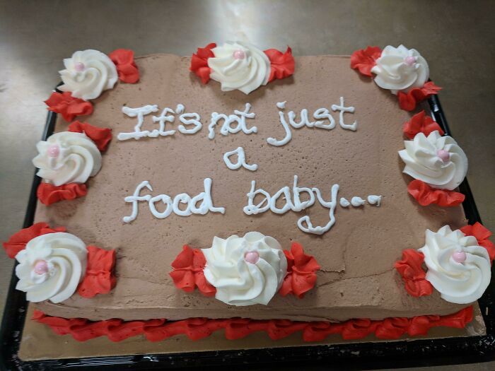 Chocolate cake with icing that reads "It's not just a food baby," featuring funny pregnancy humor.