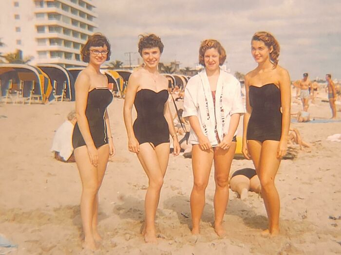 Women on a beach showcasing 60s fashion looks in retro swimsuits and hairstyles.